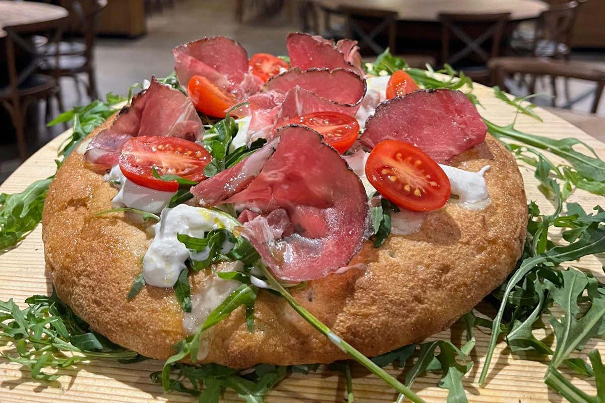 Pizza gourmet con stracciatella, coppa stagionata e pomodorini