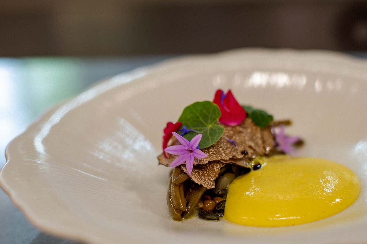 Il piatto simbolo dell'estate firmato dall'executive chef Mykyta Bida: fagiolini dorati al forno, salsa bernese, roveja, salicornia e tartufo nero