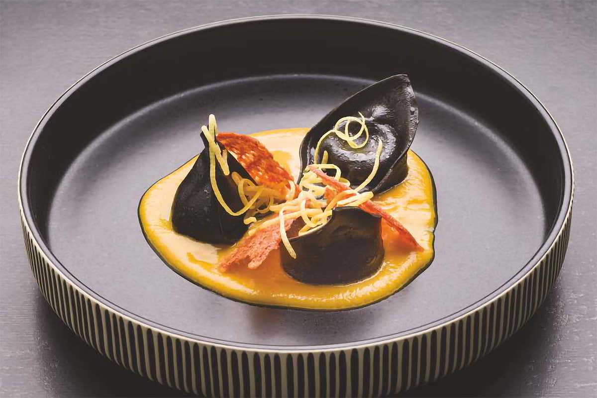 Ravioli al nero di seppia con burrata e alici in salsa di datterini gialli 