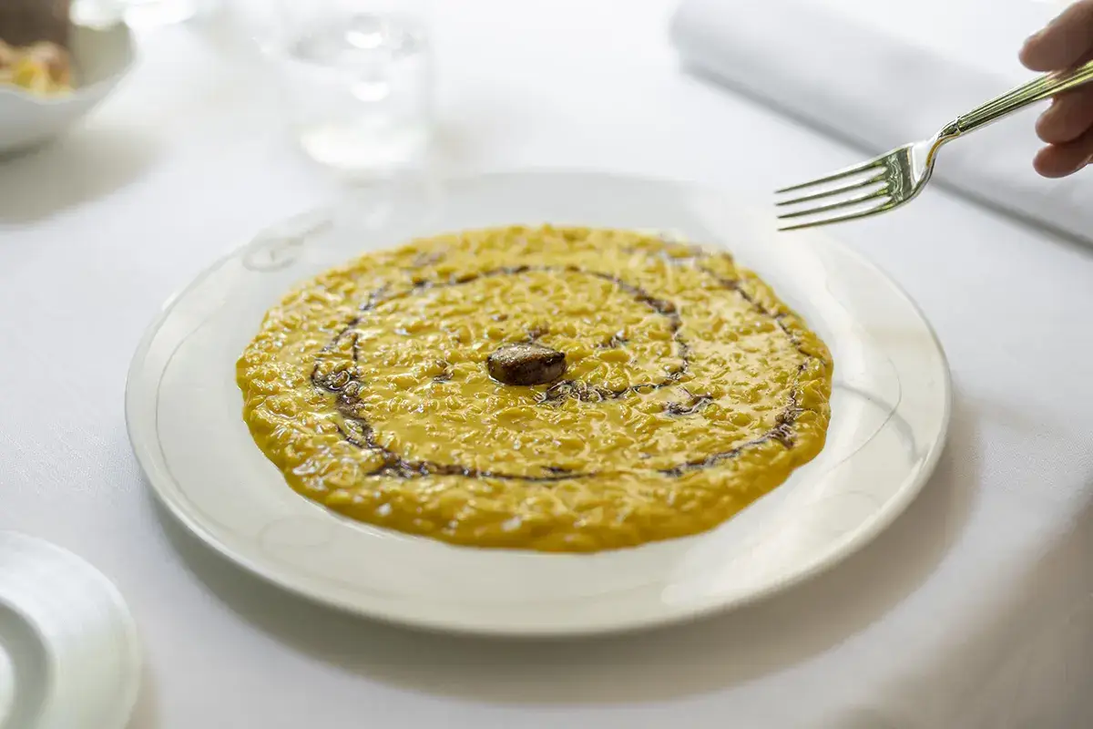 Riso selezione Carnaroli mantecato con pistilli di zafferano e caramello di vino rosso Riso selezione Carnaroli mantecato con pistilli di zafferano e caramello di vino rosso