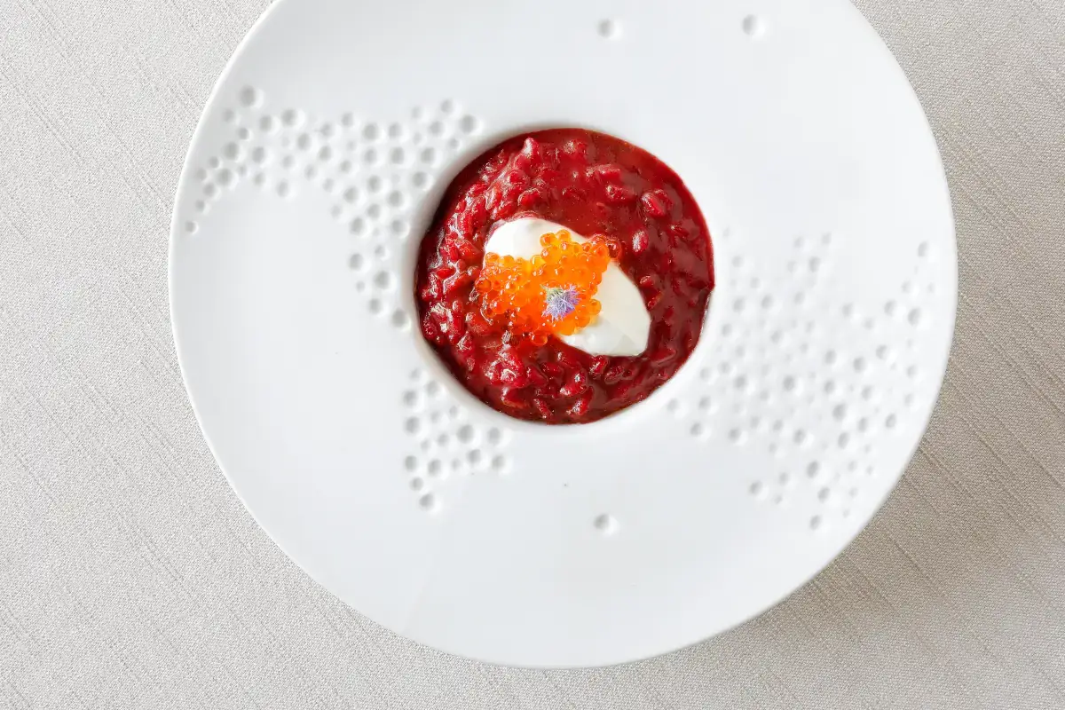 Risotto Vialone Nano mantecato alla barbabietola con crema acida e uova di salmerino gigante alpino