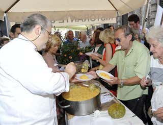 Matteo Scibilia, a sinistra, serve il risotto arancione