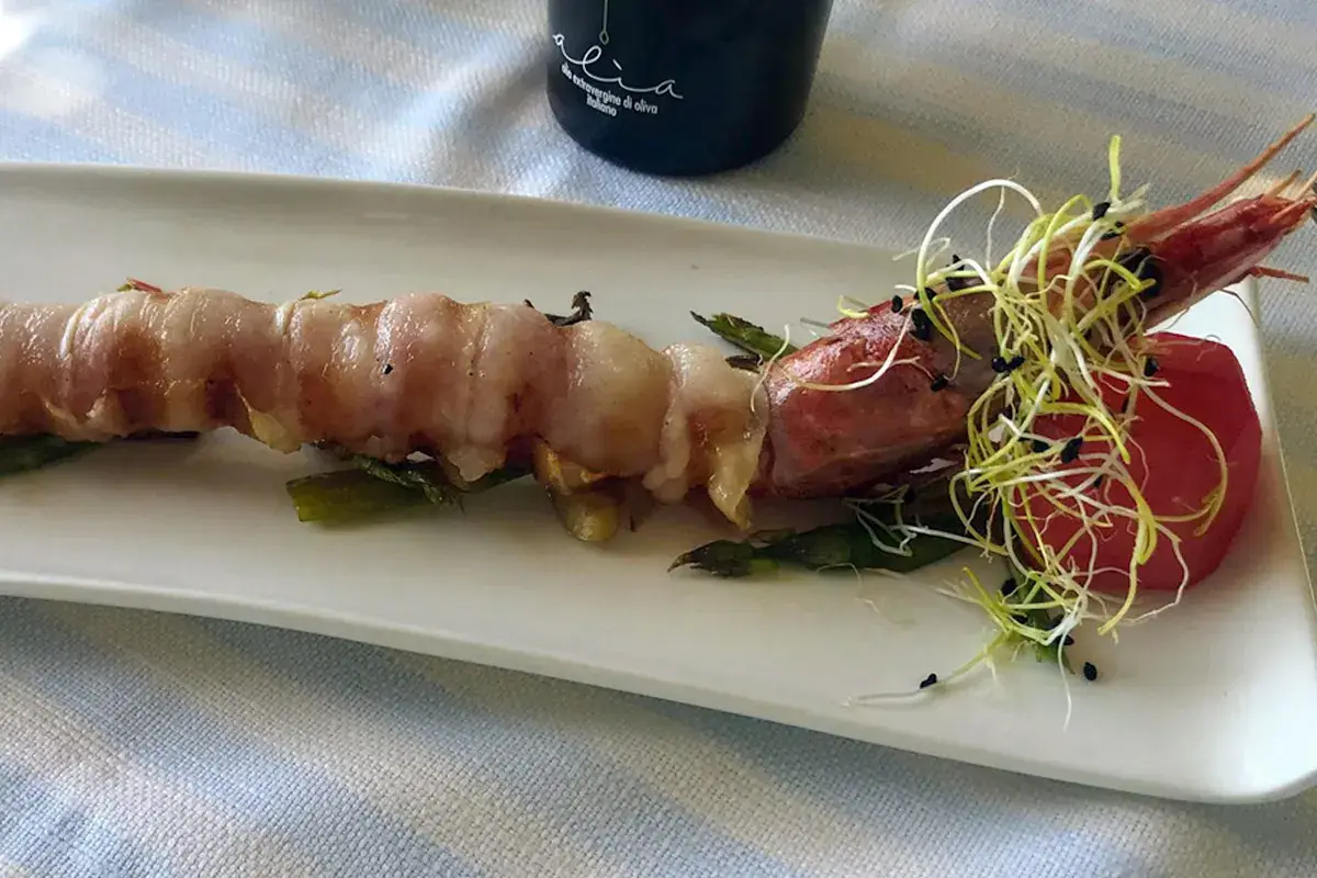 Stigliola di Gamberone con lardo sardo su zoccolo di asparagi verdi e cipollotto scalogno Stigliola di Gamberone con lardo sardo su zoccolo di asparagi verdi e cipollotto scalogno