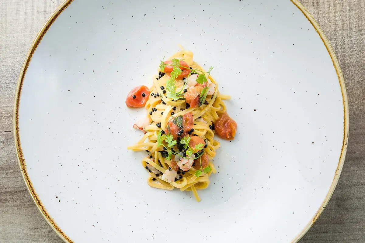 Tagliolini di pasta all&rsquo;uovo con crudaiola di gambero rosso, perlage di tartufo, Pachino appassito e buccia di limone Tagliolini con crudaiola di gambero, Pachino appassito e buccia di limone