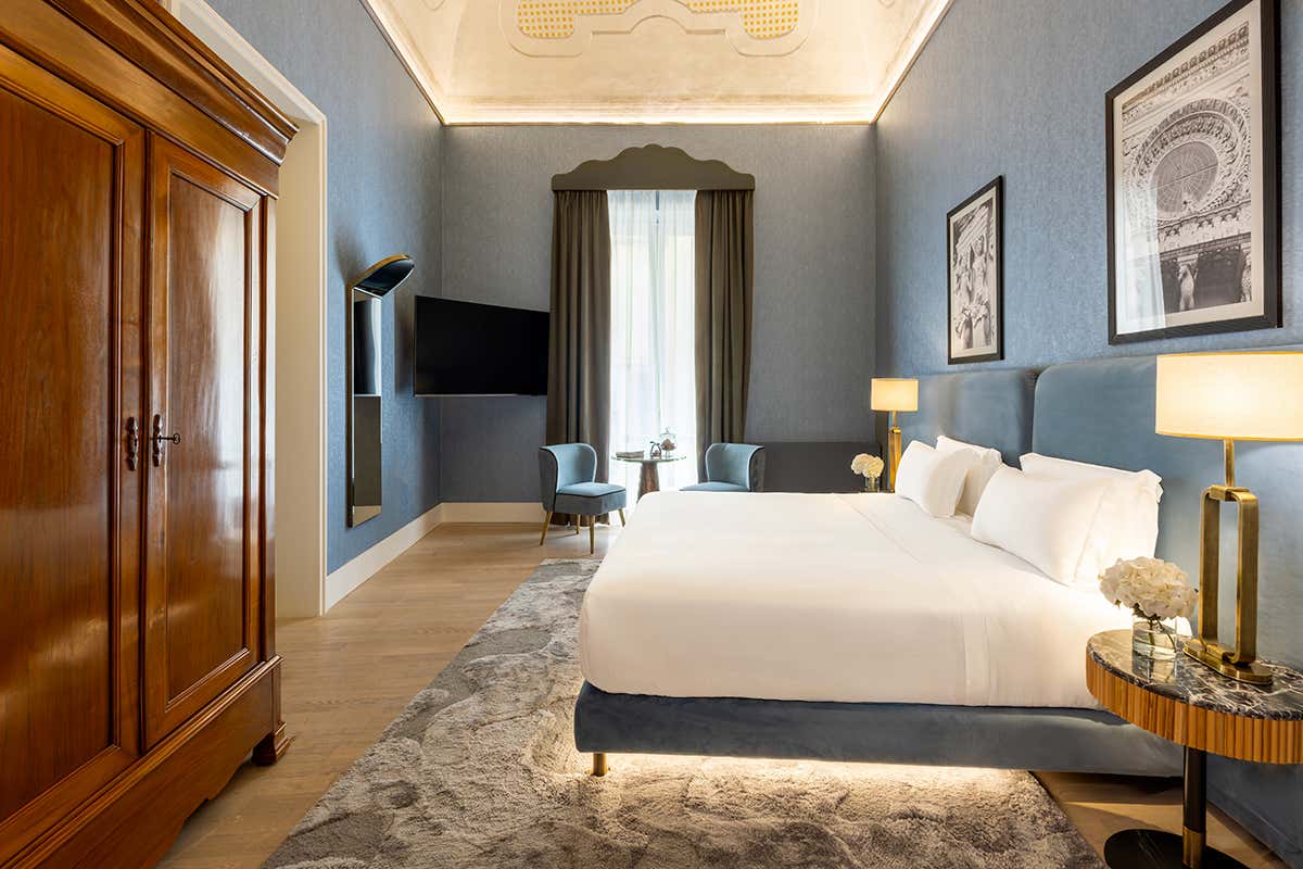 La quintessenza dell'eleganza nella Suite Presidenziale, caratterizzata da ampi spazi, alti soffitti decorati, arredi d'epoca e delicate tonalità cerulee