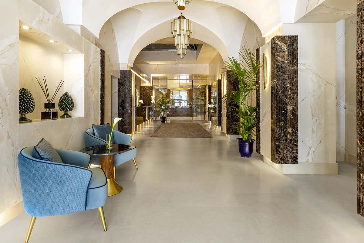 Il benvenuto nella lobby dell'hotel: dettagli in marmo, volte storiche e un design contemporaneo che dialoga con il passato