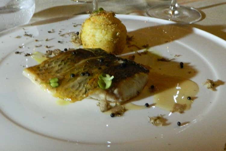 Filetto di branzino da lenza sfumato al Martini Dry con tortino di patate al tartufo estivo