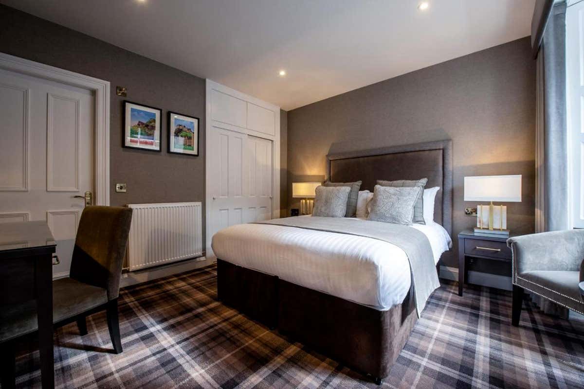 L'atmosfera intima e accogliente del The Royal Scots Club, con il caratteristico pavimento in tartan che richiama la più autentica tradizione scozzese