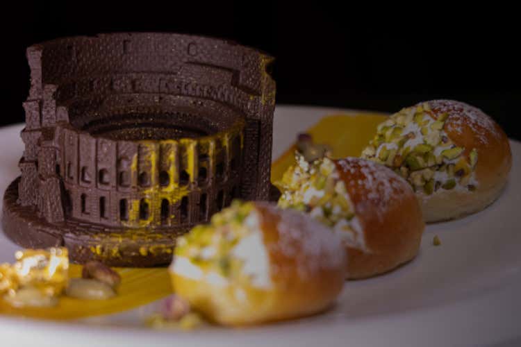 Colosseo di cioccolato, panna, crema e granella al pistacchio