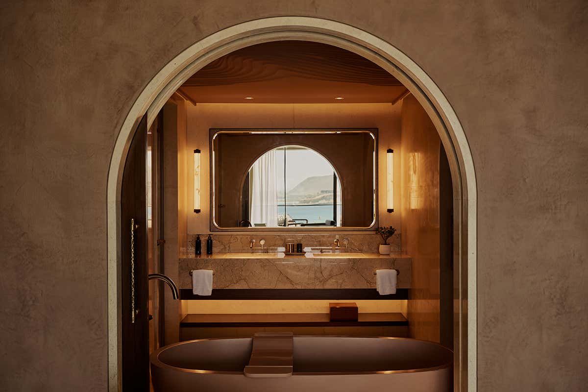 Il lussuoso design dell'ambiente bagno di una suite, dove la cura dei materiali e la disposizione degli elementi creano una cornice geometrica aperta sulla vista marina della costa saudita