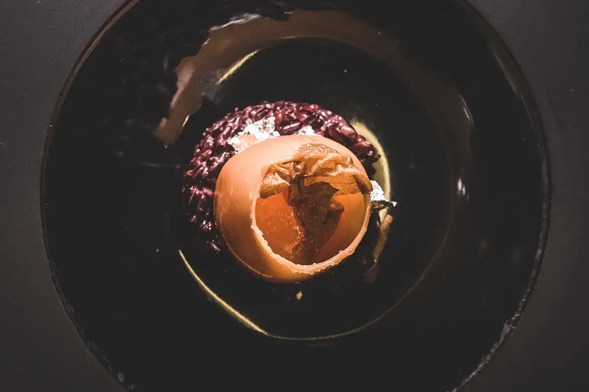 Uovo di cristallo ripieno di morbido albume, Grana Padano Dop oltre 20 mesi e patata, con il suo tuorlo su riso nero, oro e tartufo bianco &ldquo;Nati per stare insieme&rdquo; da Tano Passami l&rsquo;Olio