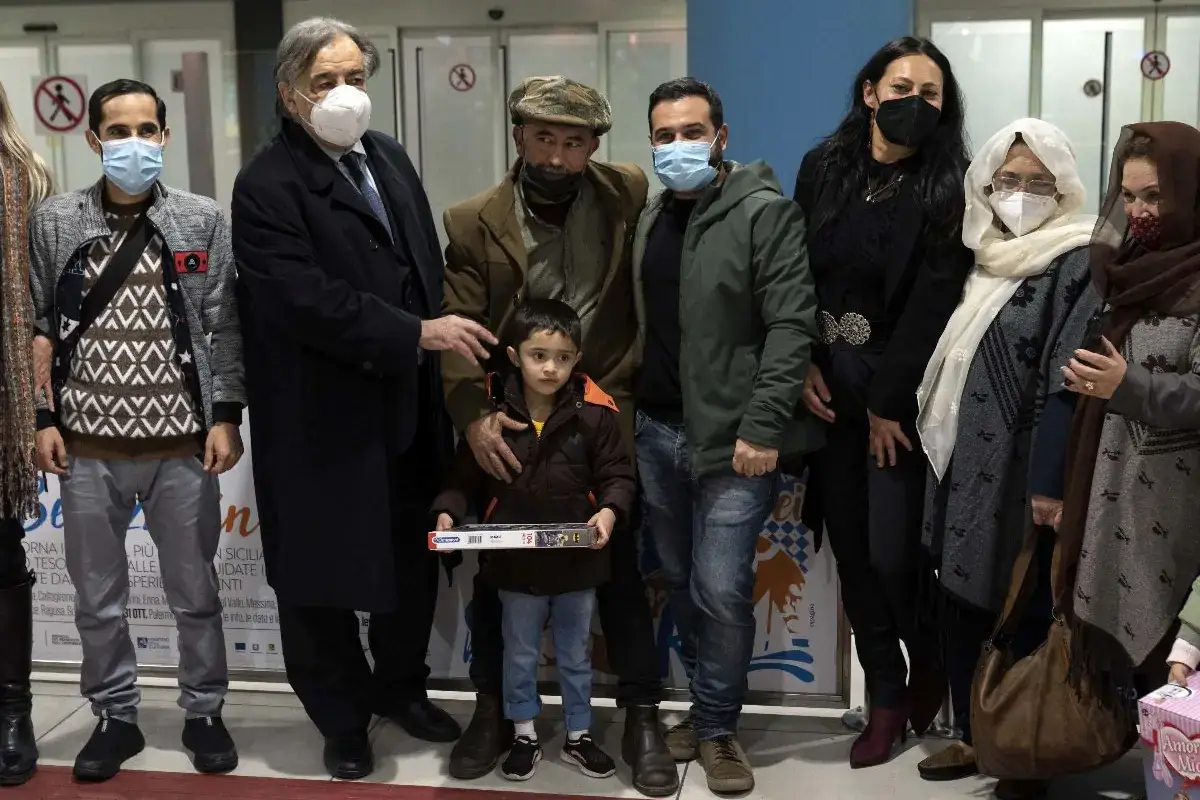 L'incontro fra Shapoor Safari (al centro con il berretto) e la sua famiglia insieme al sindaco Leoluca Orlando Dall'Afghanistan all'Italia, salva la famiglia del cuoco Shapoor Safari