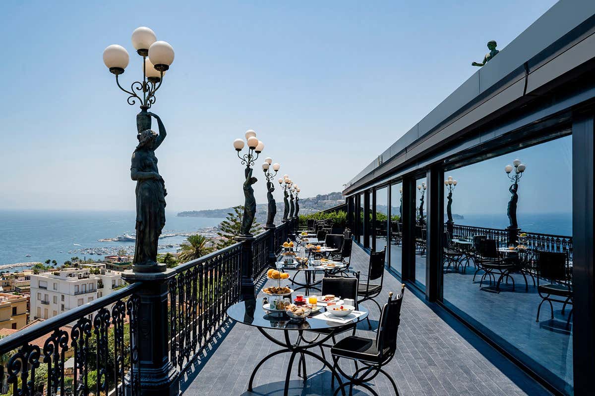 Al Bidder Terrace la colazione si gusta tra il profumo di caffè e dolci appena sfornati, con una vista mozzafiato sul Golfo di Napoli e sul Vesuvio, accompagnati dalle celebri Muse