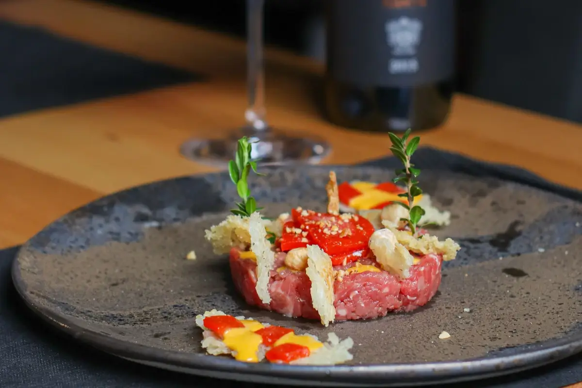 Texture Urbana &egrave; il piatto del ristorante Passaparola Bottega Contemporanea: una cialda di riso dalla texture non omogenea, una tartare di fassona servita con crema all&rsquo;uovo, gelatina di peperoni e granella di nocciole 