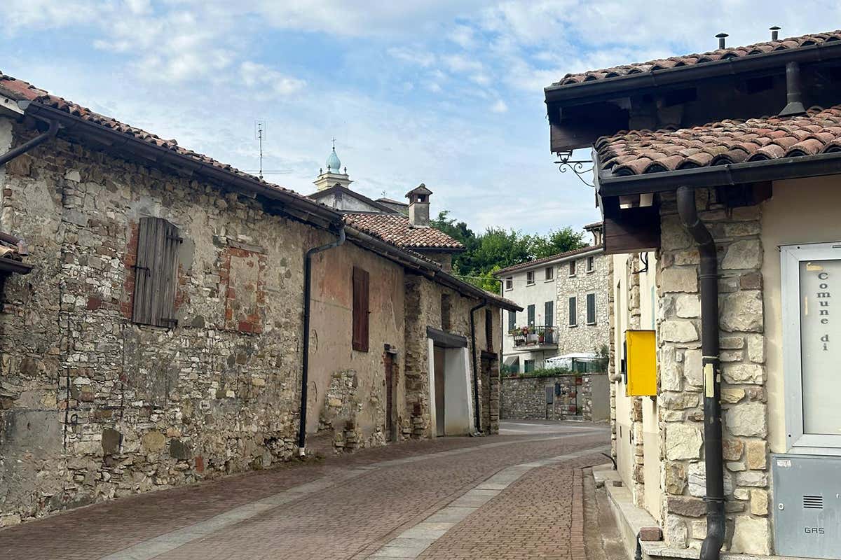 Prospettive senza tempo: tra facciate storiche e vicoli lastricati, lo sguardo si perde verso l'alto, catturando la silhouette del campanile che domina il borgo