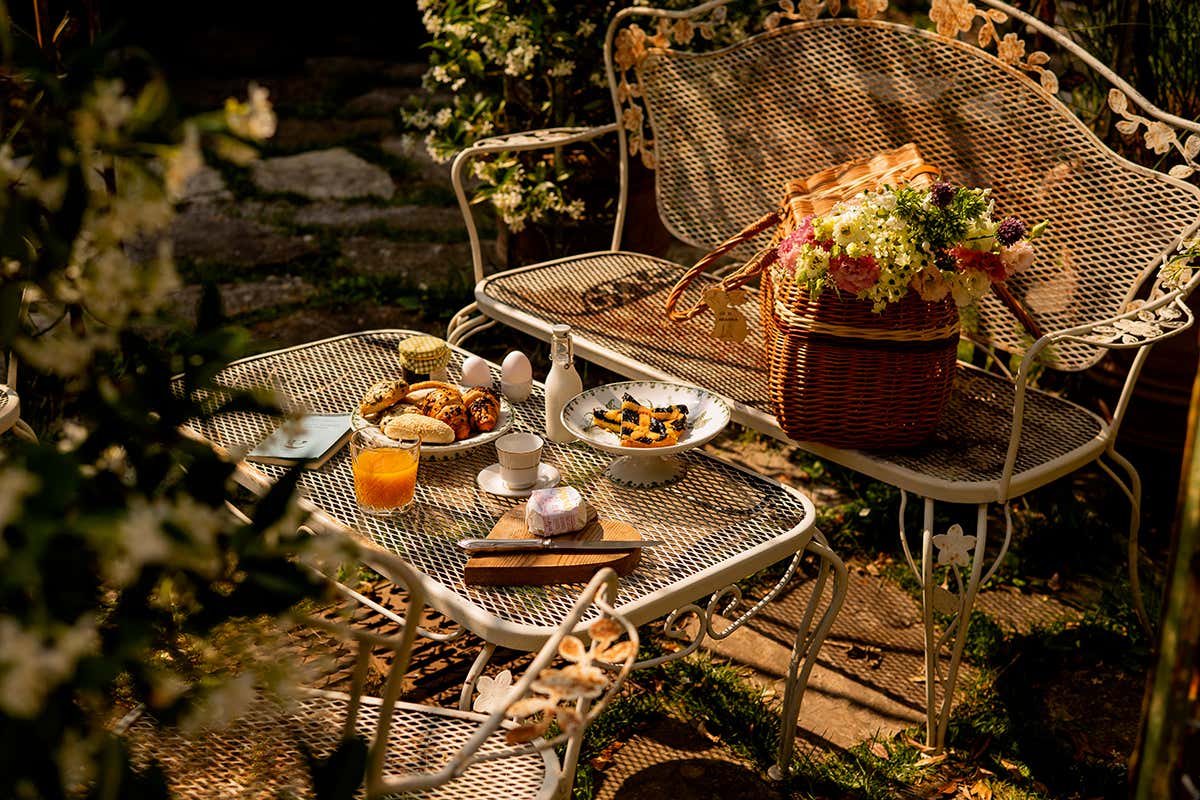 Il buongiorno al Relais: una colazione intima e lenta servita nei giardini delle ville, tra tavolini in ferro battuto, crostate artigianali e il silenzio  della natura