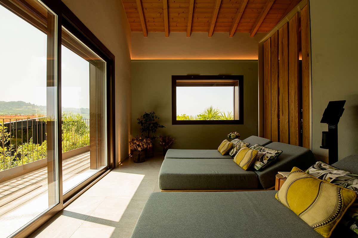 La stanza del silenzio e della meditazione: comode chaise longue e ampie vetrate panoramiche che incorniciano il profilo dell'Oltrepò Pavese