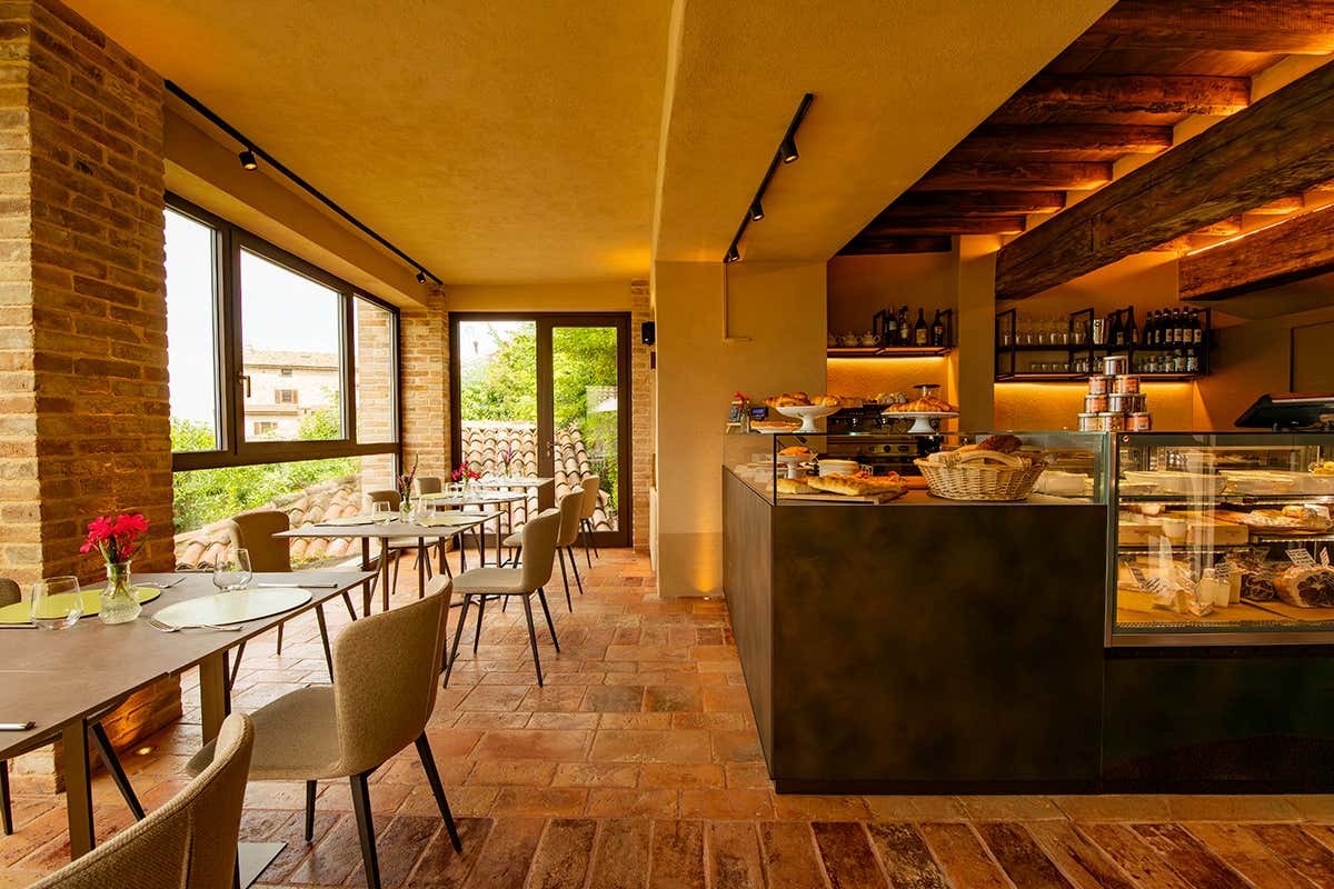 L'atmosfera calda e accogliente de La Bütega: mattoni a vista, legno antico e una vetrina di eccellenze gastronomiche locali