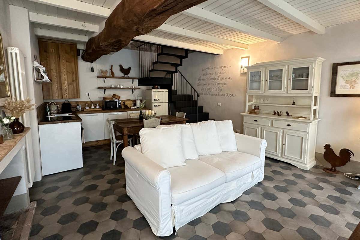 La zona giorno di Cà dell'Erminia: un equilibrio tra il fascino rustico delle travi a vista secolari, le cementine esagonali e un arredo che profuma di casa