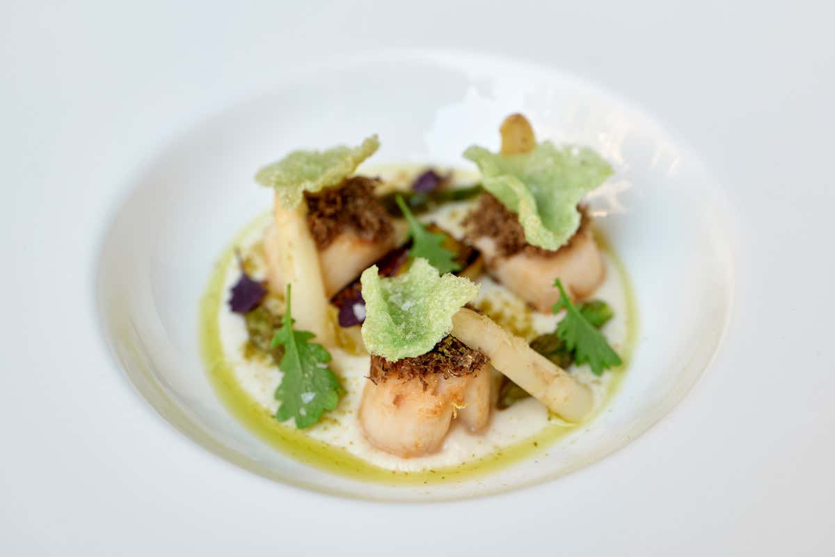 Capasanta scottata con asparagi bianchi e verdi, battuto di capperi di Pantelleria, limone confit, porro arrosto, salsa alla mandorla