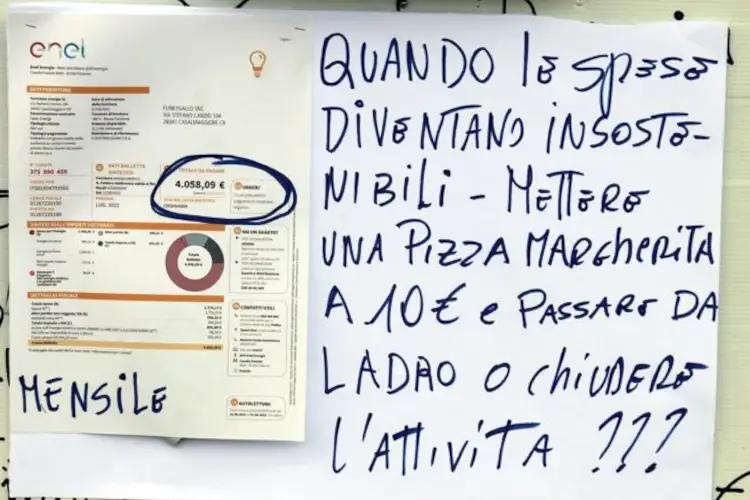 Il cartello esposto da Alberto Rovati sulla fetrina della pizzeria (foto Corriere della Sera) Insieme al menu anche la bolletta: &ldquo;Ecco perch&eacute; la mia pizza costa 10 euro&rdquo;