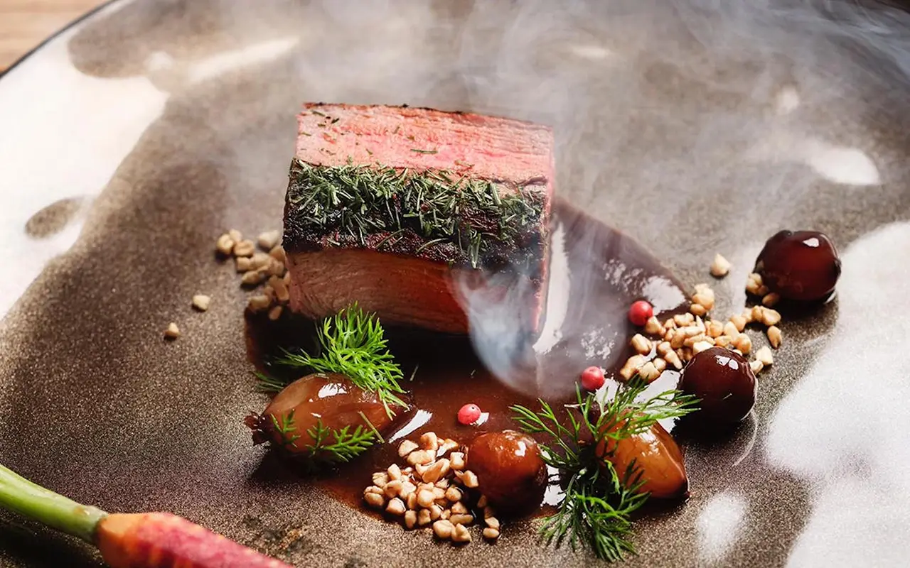 Filetto di cervo in crosta di aneto col suo juice al pepe rosa, accompagnato da cipolline cotte in aceto di Modena, granella di mandorle pralinate salate e carotine di Putignano Disegna la tua vacanza sulle Dolomiti: le novità del Bonfanti di Chienes