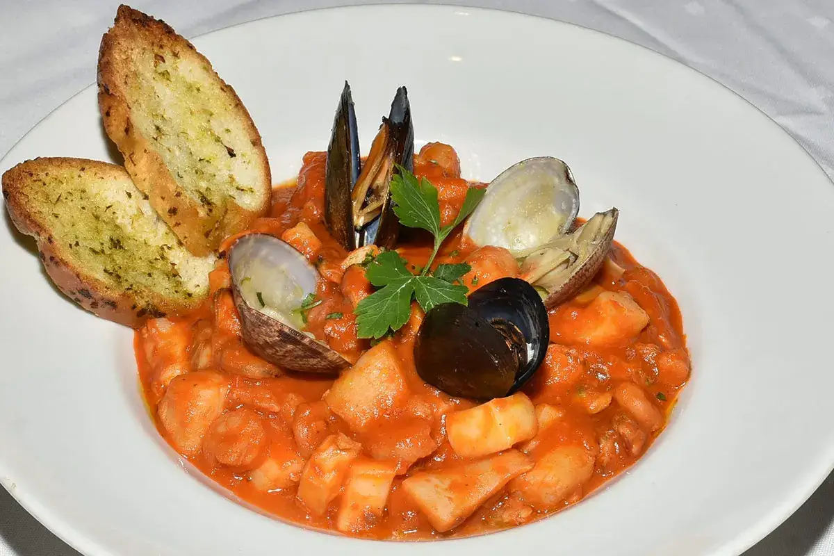 Cioppino - Zuppa di pesce, cozze e vongole in salsa di pomodoro leggermente speziata, crostini all'aglio Cioppino