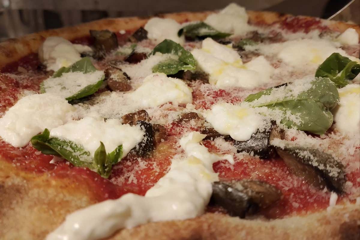 Pizza Normigiana: pomodoro e melanzana in cottura; in uscita, burrata, basilico e Parmigiano Reggiano