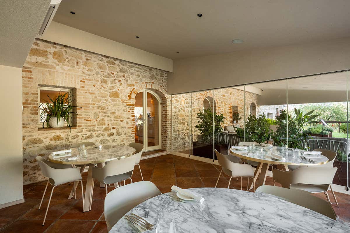 La sala interna del Ristorante Il Gusto, uno spazio luminoso che unisce la storicità delle pareti in pietra a elementi d'arredo chic e contemporanei