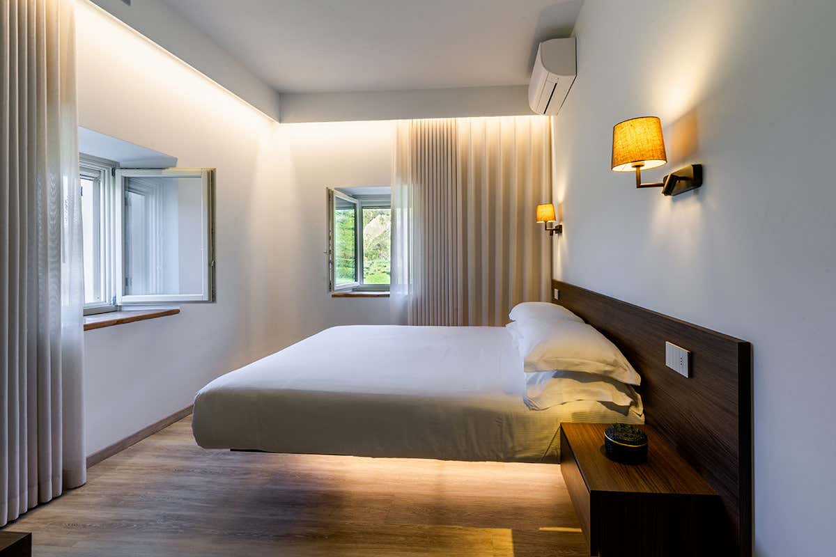 Il design essenziale e moderno delle sistemazioni sospese di Colle Serrano, studiate con illuminazione calda per esaltare l'atmosfera rilassante e la vista sulla natura