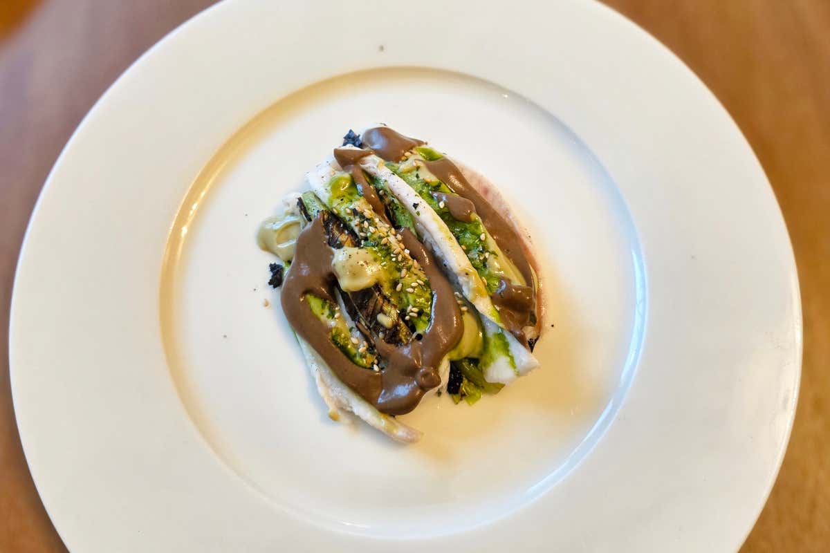 Sogliola in olio cottura, servita con lattuga alla brace e salsa di noci con fondo di sogliola