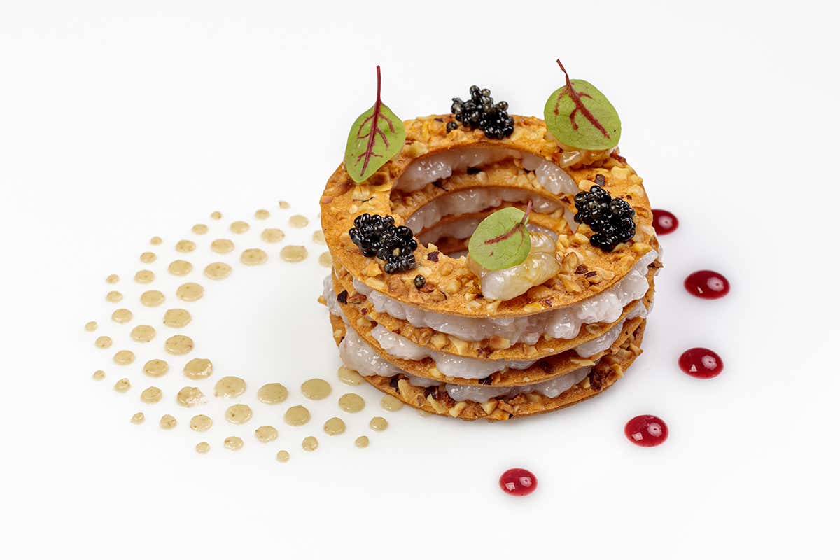 Sandwich marino con strati di tartare di scampi intervallati da cialde croccanti con caviale nero