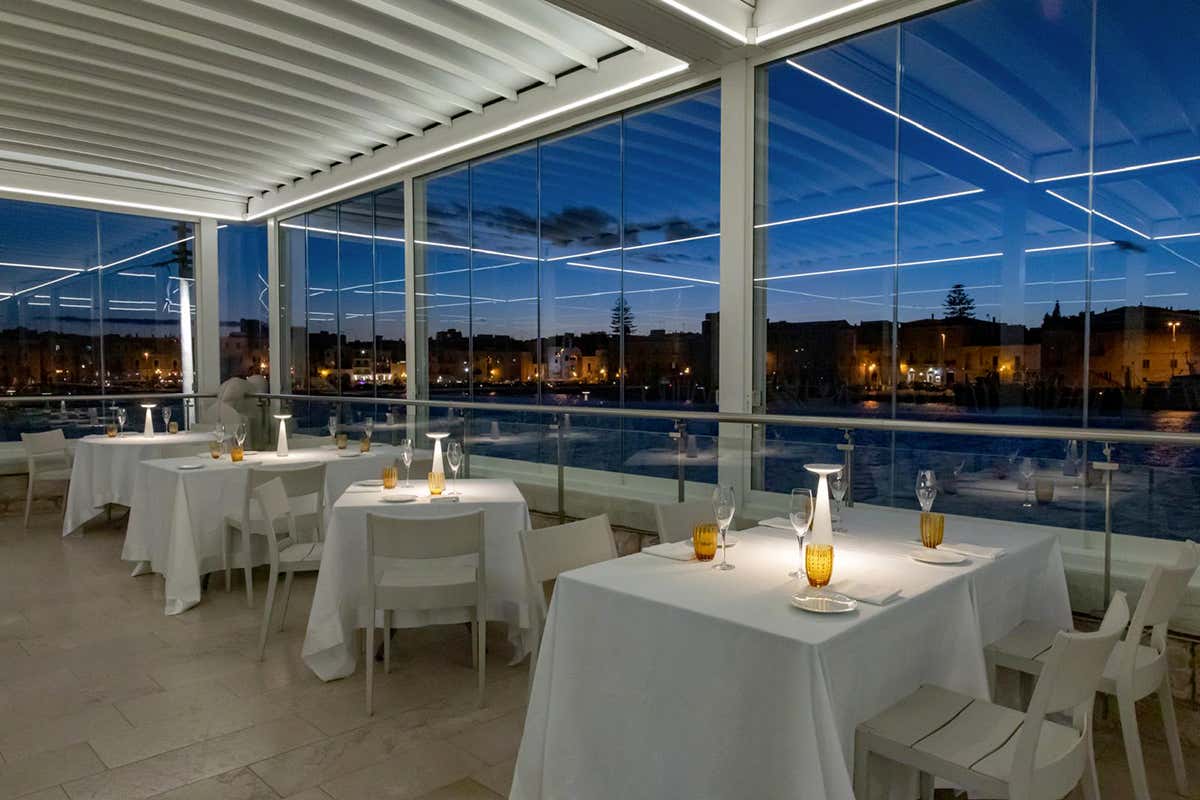 L'elegante terrazza panoramica del ristorante che si affaccia direttamente sul porto storico di Trani