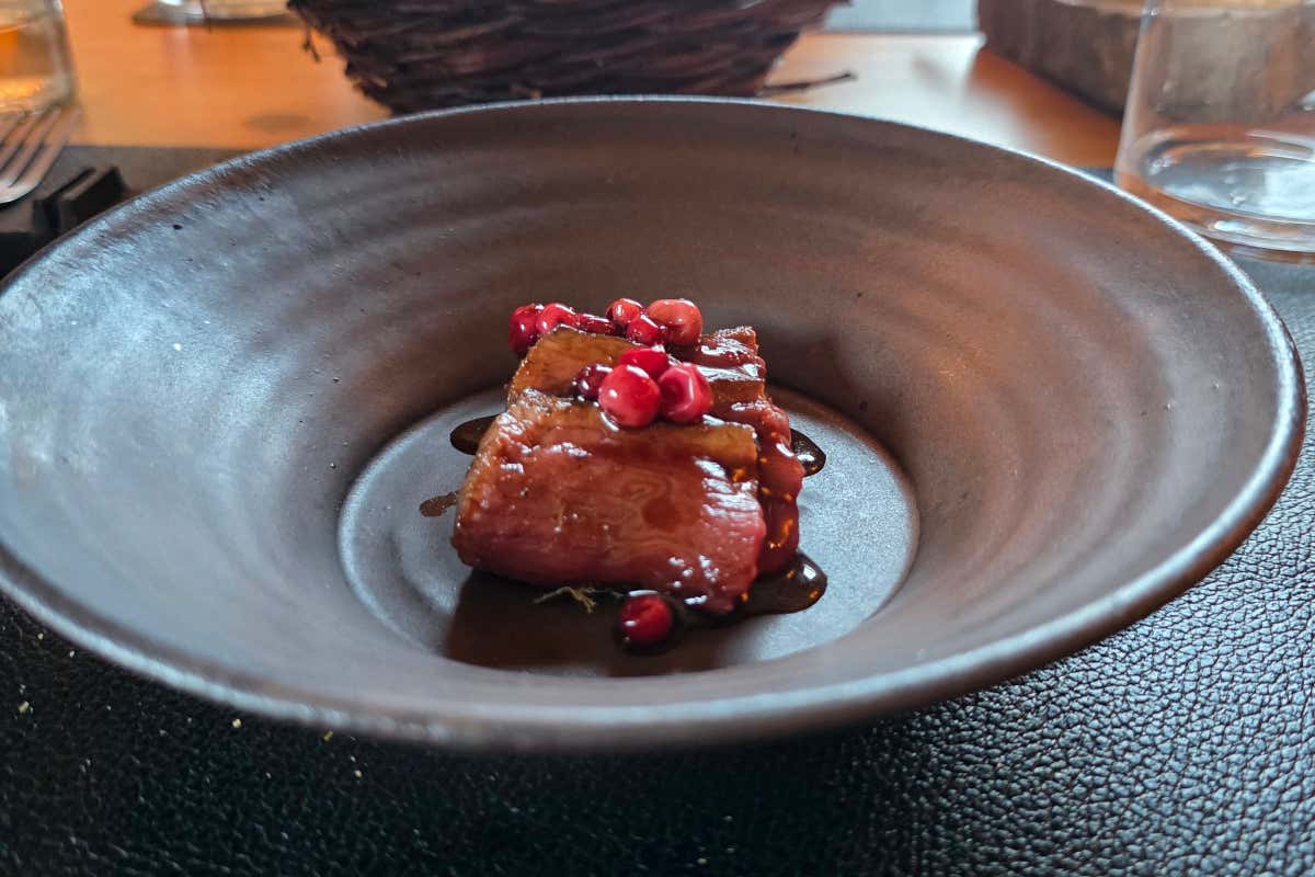 Cervo alla brace, affumicato con aghi di abete bianco e servito su base di pesto di aghi di abete, con una salsa all’aceto di rosa, mirtillo rosso e olio all’abete bianco