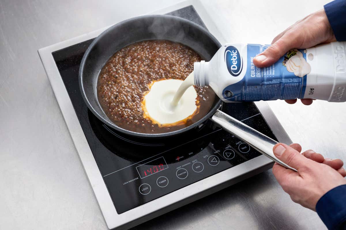 Una fase della preparazione della salsa al pepe affumicato con panna Debic Culinaire Original
