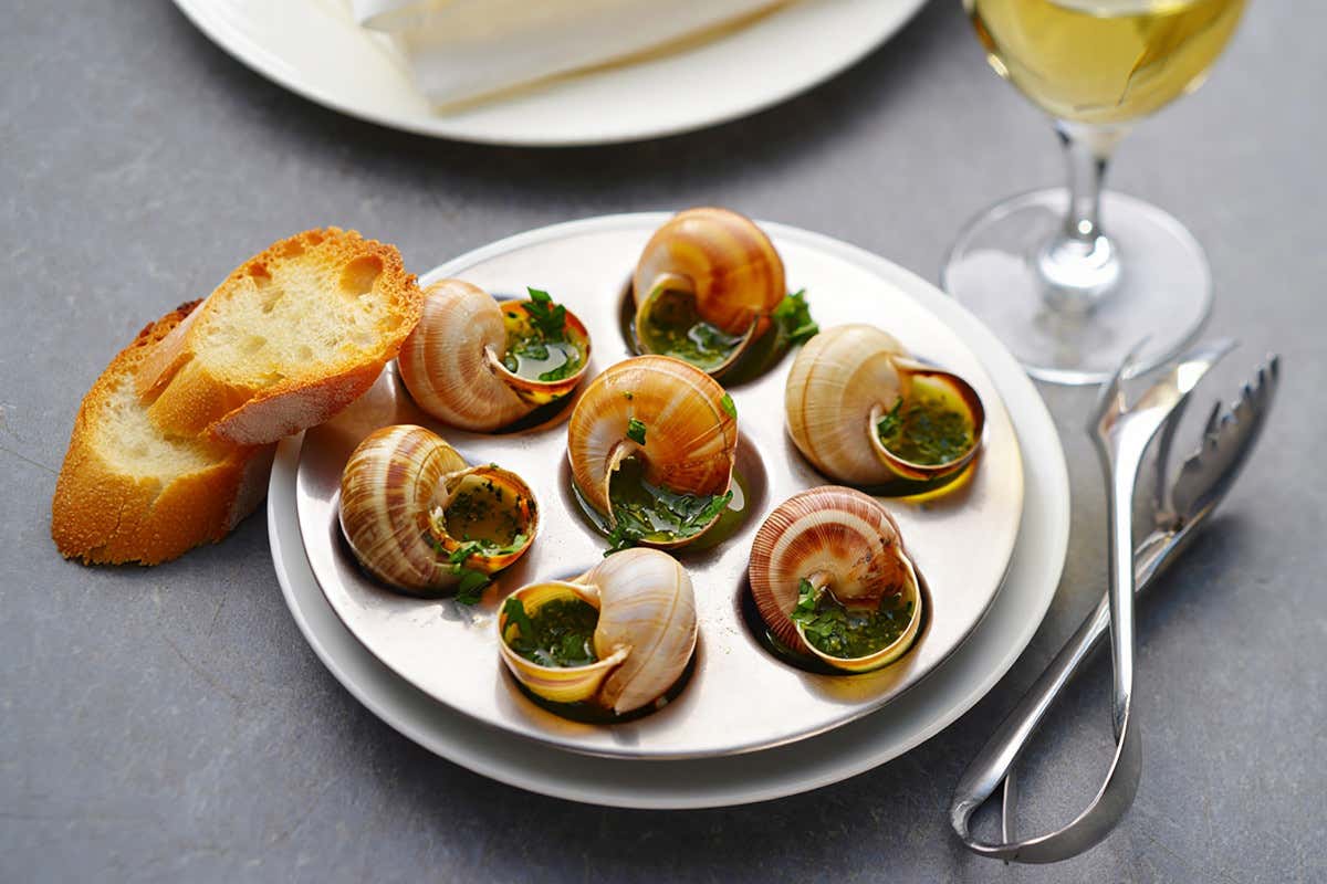 Le escargots vengono tradizionalmente servite nel guscio con burro aromatizzato