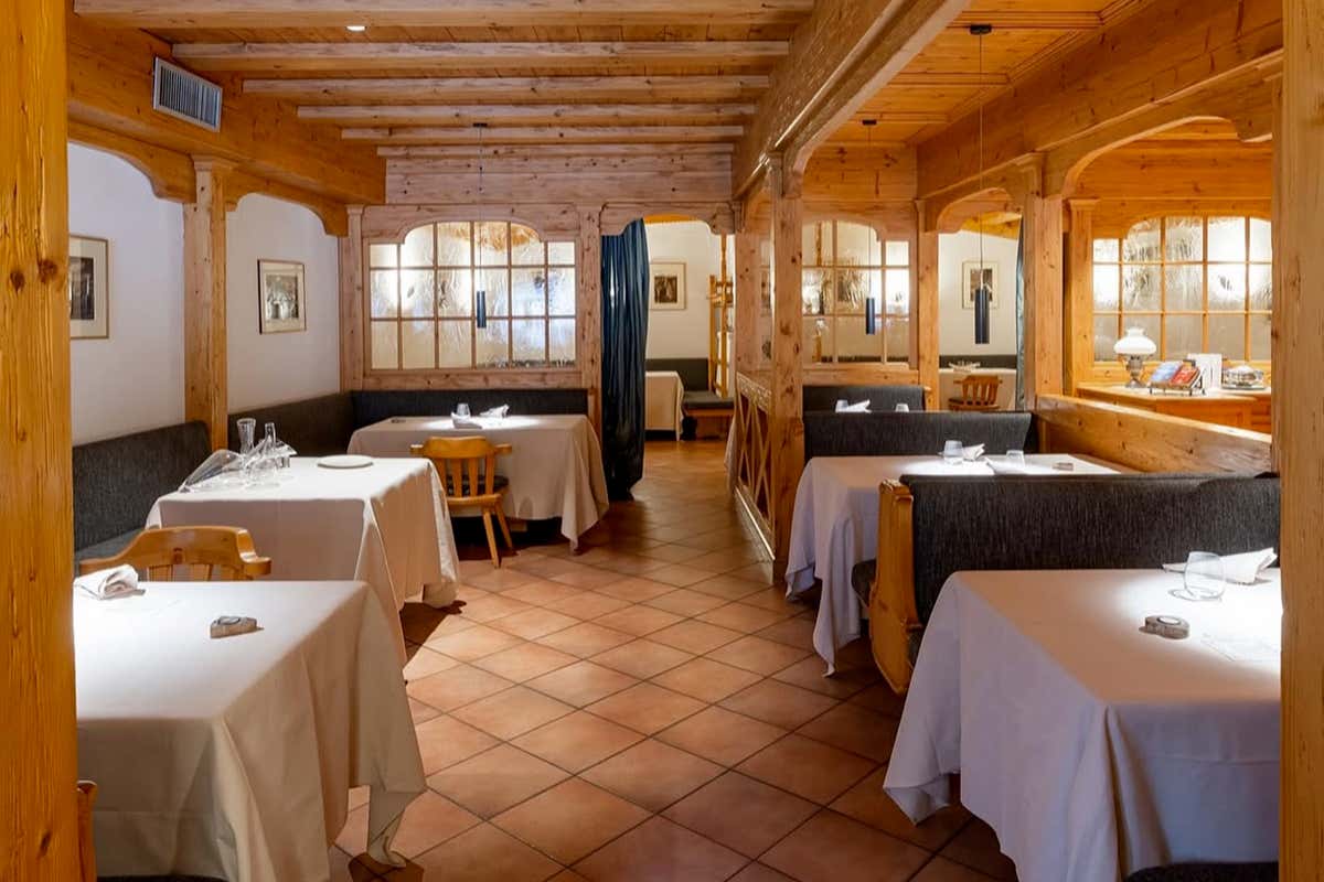 All'interno dello Sport Hotel Alpina, l'eleganza contemporanea incontra il calore delle boiserie storiche al ristorante Il Cantinone