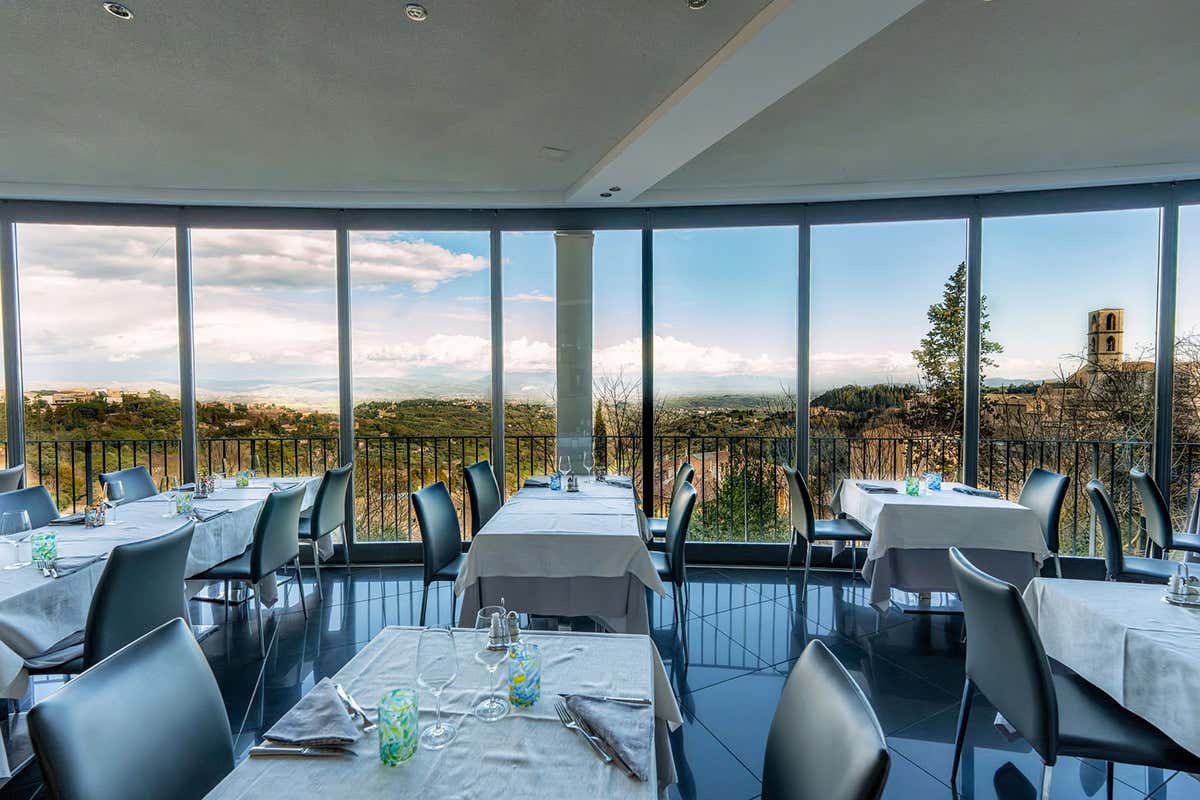 La vista dalle vetrate del Ristorante del Sole, il luogo ideale per mangiare sospesi tra i tetti medievali di Perugia e l'infinito delle colline umbre