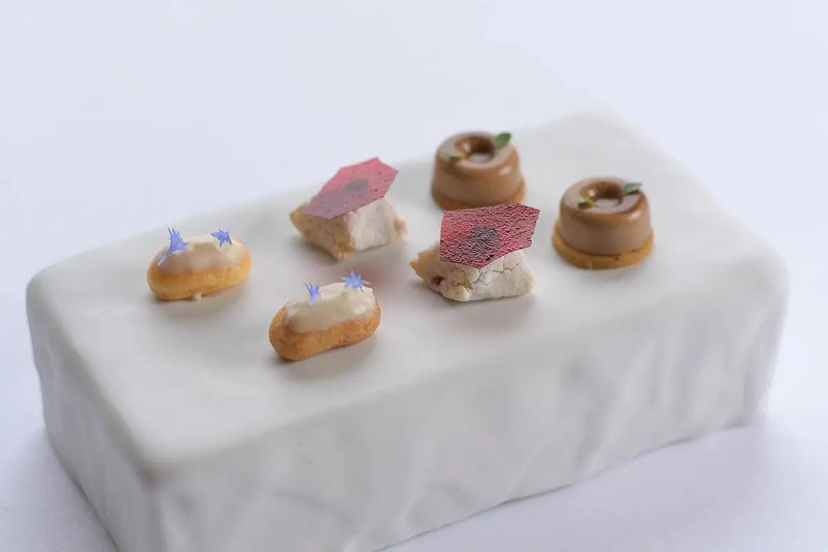 Petits fours, Budino di riso al vin santo, Ricciarello al lampone e vermouth di prato, Panna cotta al caffè, frolla al cappero e maggiorana, Caramella al gin tonico botanico home made, cetriolo marinato all'aceto di riso e lime Tentazioni toscane al ristorante del Villa San Michele