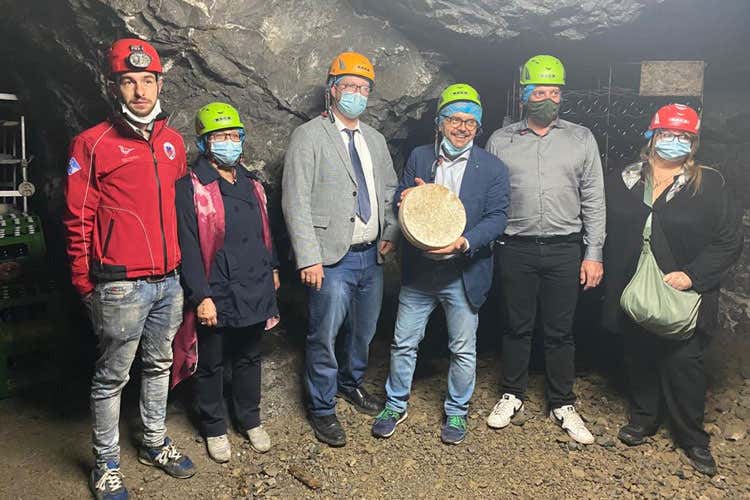 La visita in miniera, al centro con la forma di formaggio, l'assessore regionale Fabio Rolfi - Formaggi stagionati nelle miniere Al via un progetto nel Bergamasco