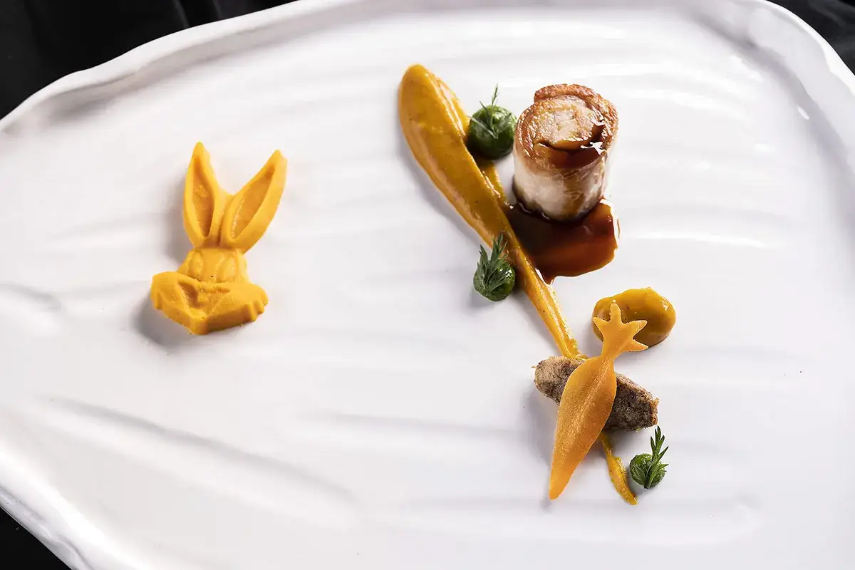 Rollé di coniglio, erbe, carote e rucolino