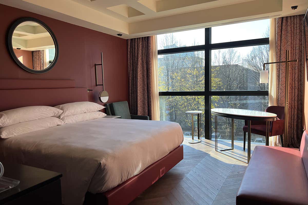 Le linee calde ma essenziali di una delle luminose camere Hilton Rome Eur La Lama eleganza contemporanea