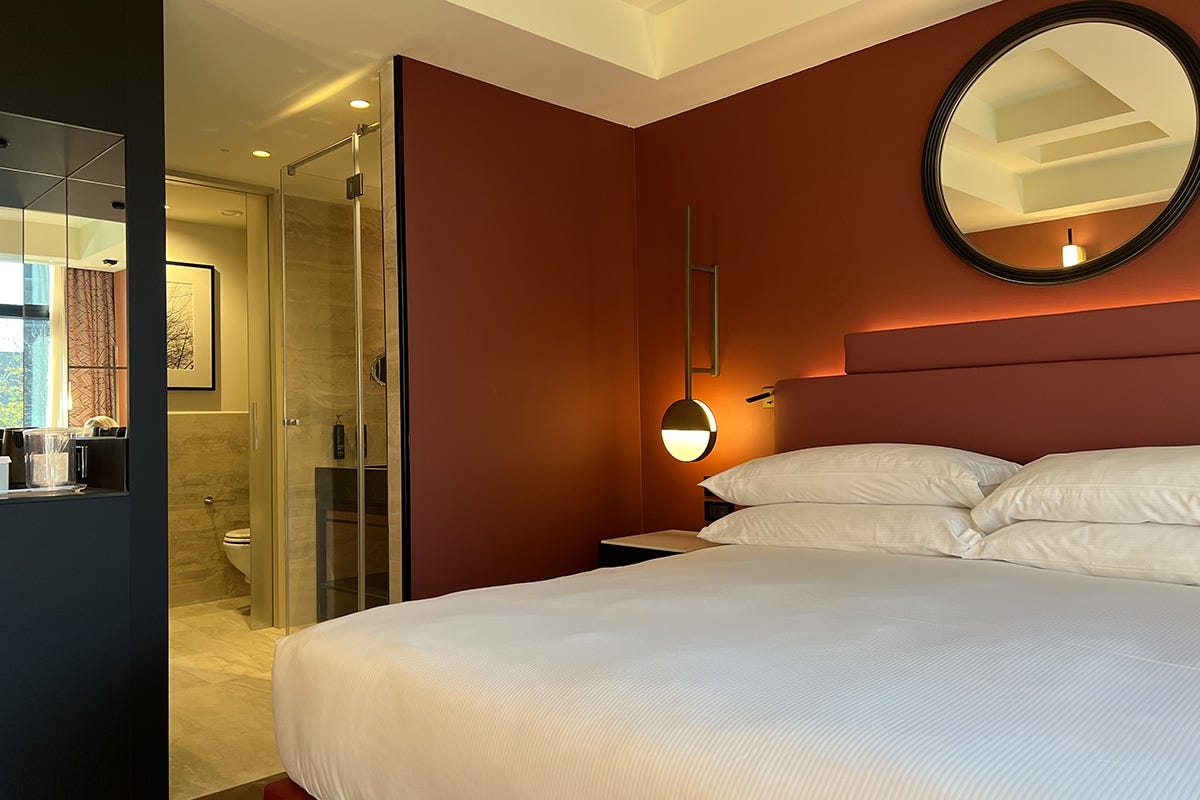 Camera da letto e bagno di una delle 439 camere Hilton Rome Eur La Lama eleganza contemporanea