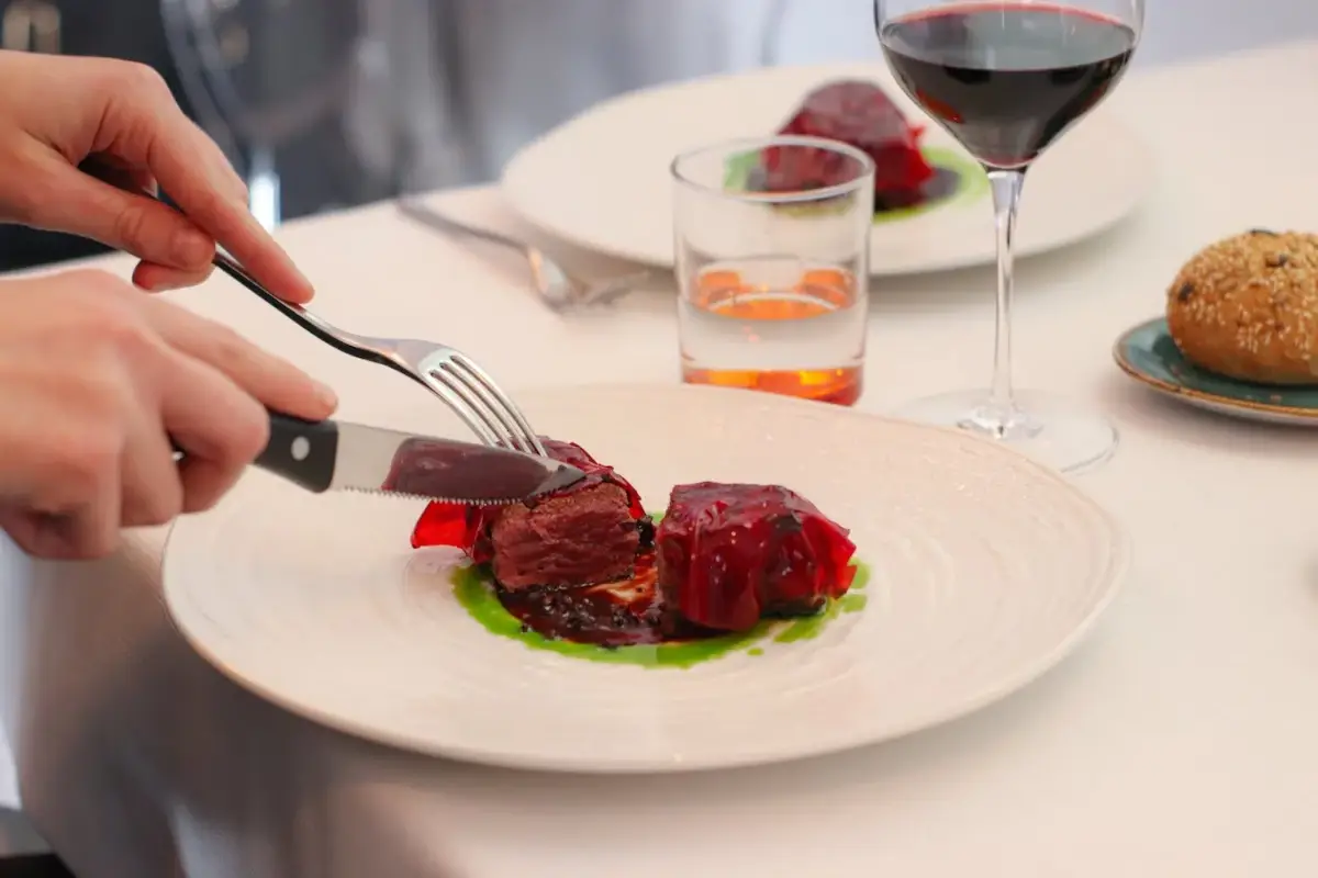 Filetto di cervo in crosta di fave di cacao, ristretto al porto, cioccolato e ginepro e velo di melograno: un piatto del menu ell&rsquo;artista di Elisa Hoti della Trattoria La Madia 