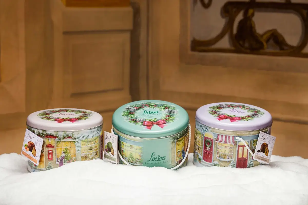 &Egrave; una latta realizzata con tre livelli di rilievo per dare una profondit&agrave; sensoriale, il cui coperchio racchiude il panettone con una ghirlanda di buon augurio 