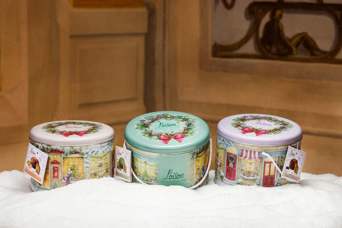 &Egrave; una latta realizzata con tre livelli di rilievo per dare una profondit&agrave; sensoriale, il cui coperchio racchiude il panettone con una ghirlanda di buon augurio 