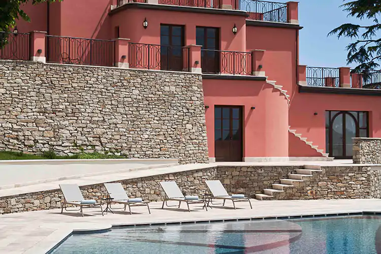 La piscina con alle spalle la casa colonica dell'800 in cui sorge Nordelaia Nordelaia, il boutique hotel nel cuore del Monferrato
