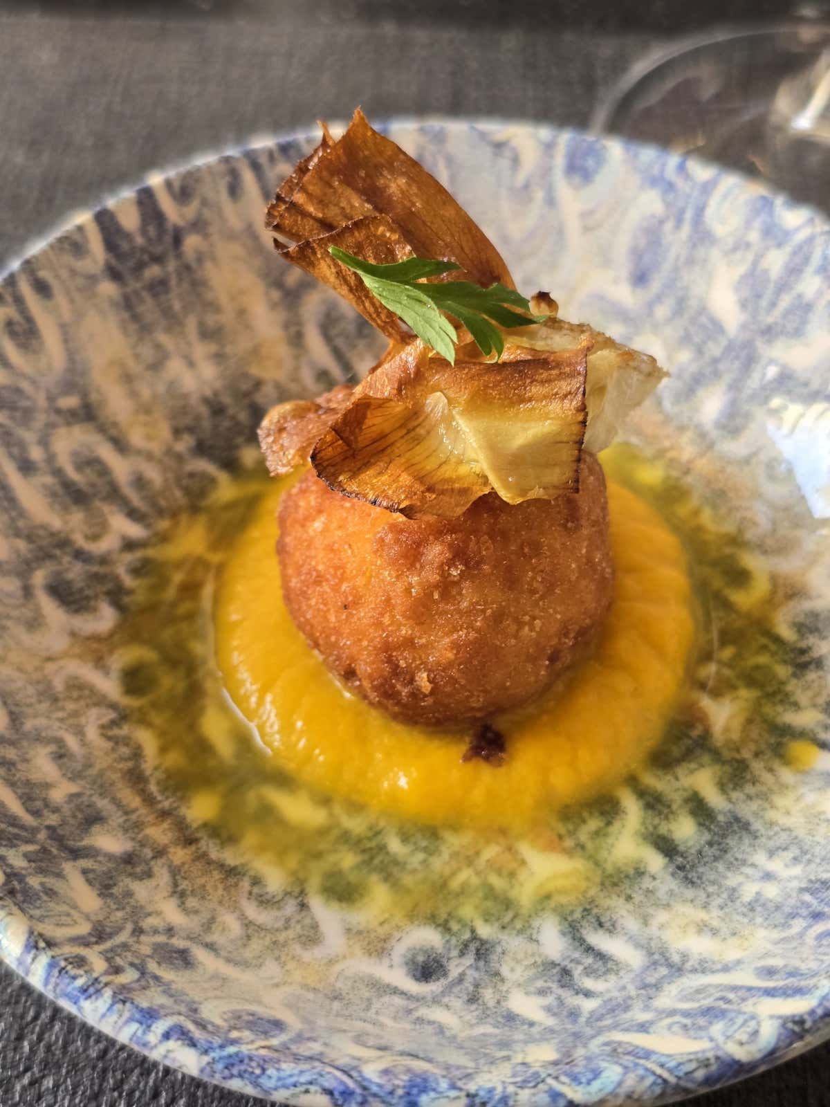 Arancino alla pescatora con pomodorino giallo e carciofo alla giudia