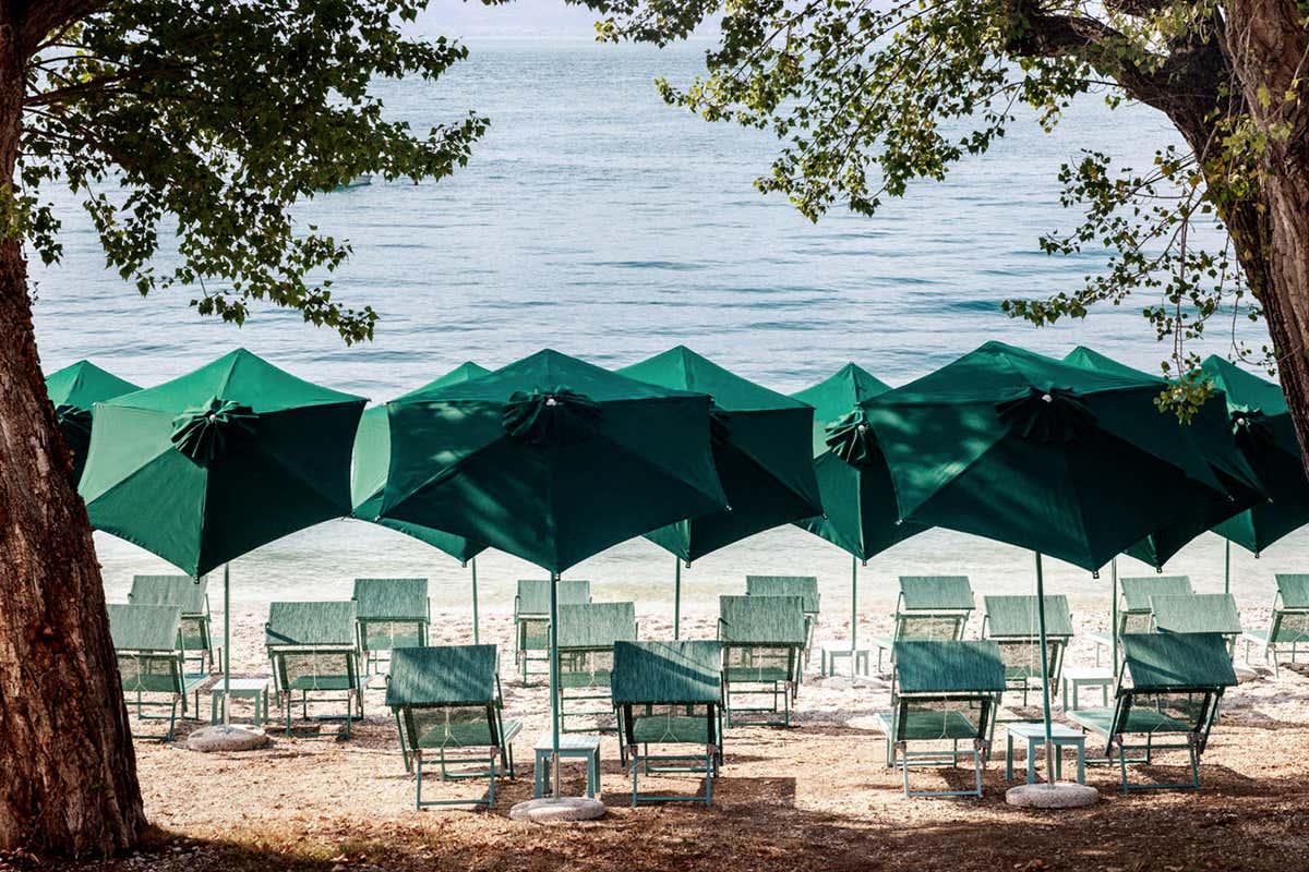 Riviera Beach Club il vero lusso è lo spazio: i lettini e gli ombrelloni verdi si integrano perfettamente tra gli ulivi secolari, preservando il dialogo con il paesaggio