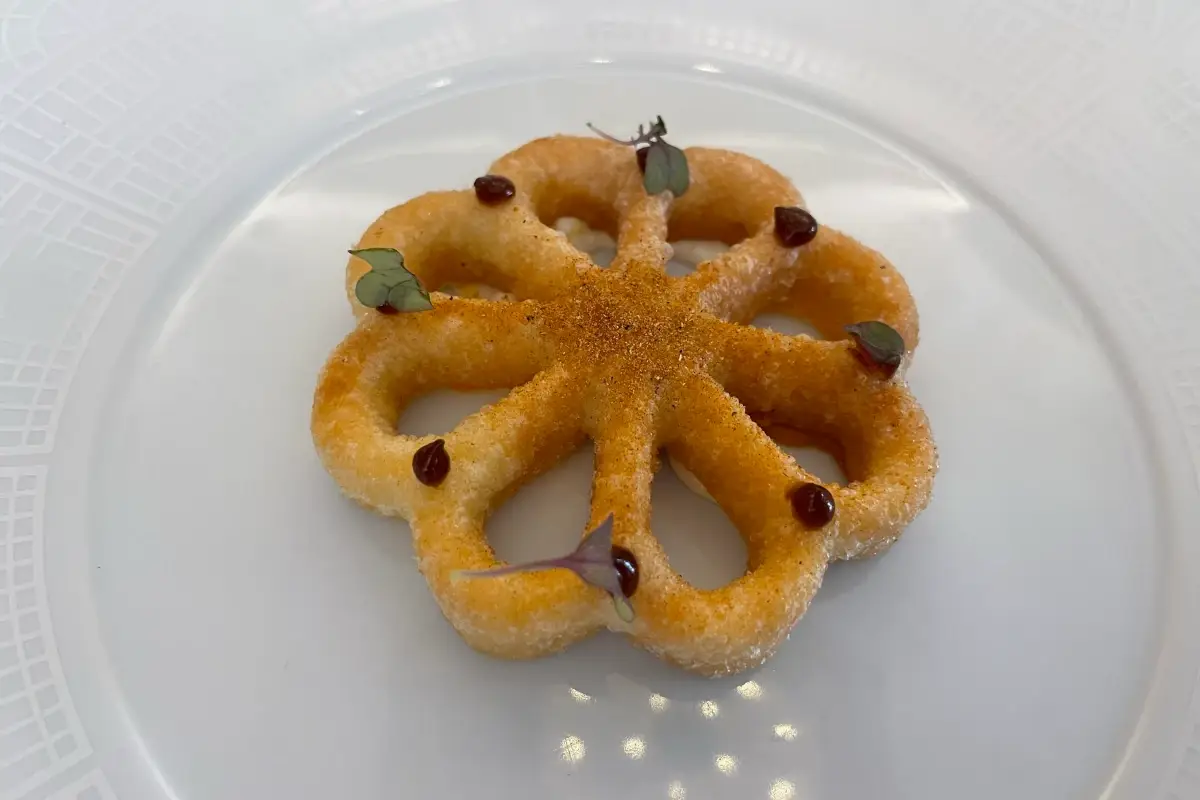 Croccante di patate soffiato ripieno con baccalà mantecato e peperoni arrosto. Sopra gel all'aglio nero fermentato Enoteca la Torre Villa Laetitia, esperienza esclusiva nel cuore della Capitale